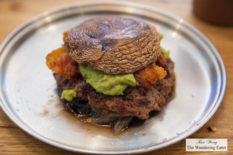 Grass-Fed Burger with portobello mushroom cap "buns" with caramelized onions, avocado and bacon